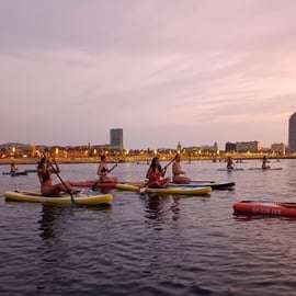 Paddleboarden bij zonsondergang langs de kust van Barcelona